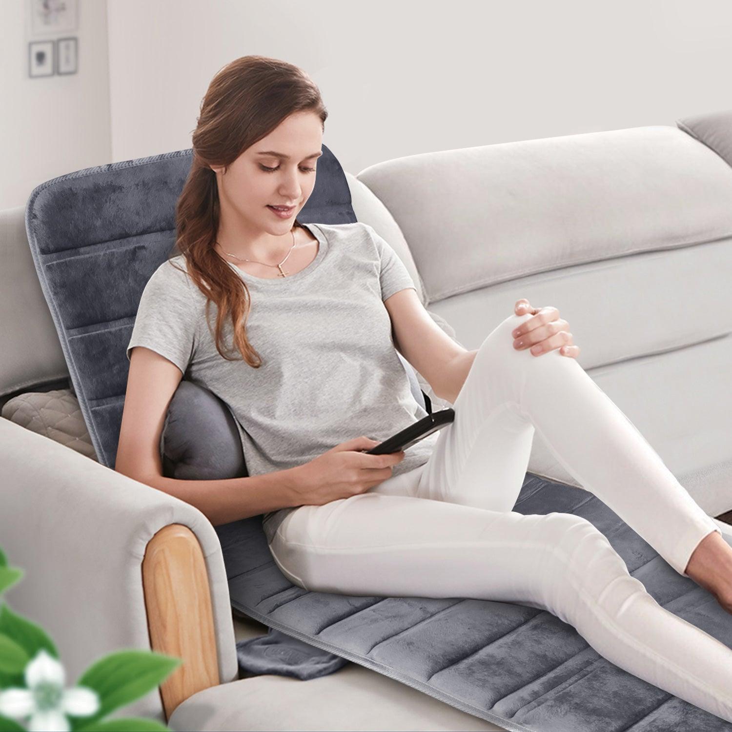 Woman Relaxing on Comfier Massage Mat While Using Phone